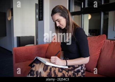 Secretary takes notes for business appointments on her agenda, millennial woman concentrated on writing. Stock Photo