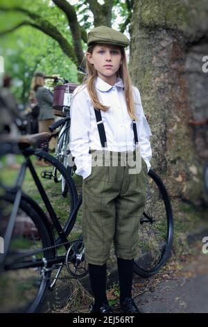 young girl wearing plus fours standing beside bicycle at Tweed Run in London , UK Stock Photo
