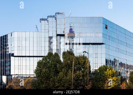 The glass facade of University College Hospital (UCLH) at 250 Euston Road, reflecting the BT Tower, London, UK Stock Photo