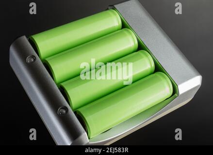 Photo of green colored lithium accumulator batteries in charger on black background. Stock Photo