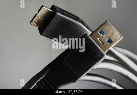 Close-up photo of black usb cables on grey background. Stock Photo