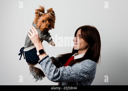 Young attractive woman with dog yorkshire terrier smiles. Close up photo. Pet care. People and pets. Girl holds brown dog isolated on white background Stock Photo