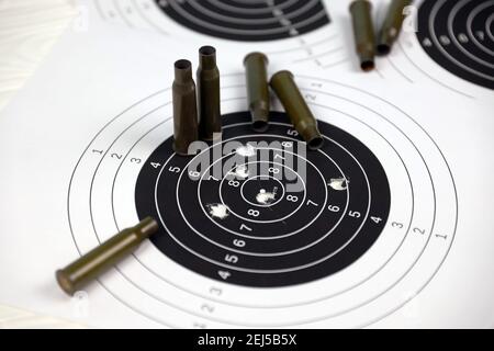 Many bullets with shooting targets on white table in shooting range polygon. Training for aiming and shooting accuracy Stock Photo