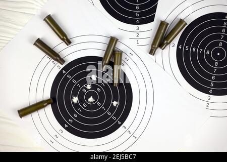Many bullets with shooting targets on white table in shooting range polygon. Training for aiming and shooting accuracy Stock Photo