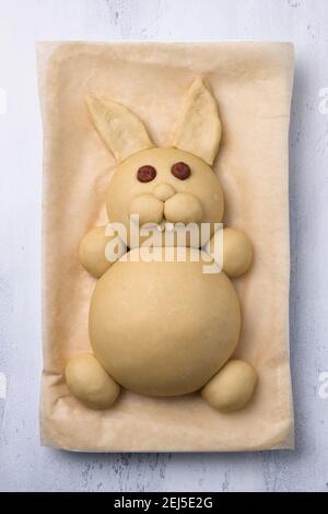 A process of making Easter Bunny Buns of delicious sweet dough. Do it yourself. Step by step instruction. Step 4. Make of almond petals a teeth and an Stock Photo