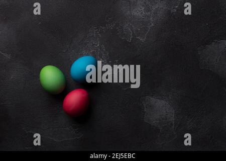 Easter eggs on black textured background, top view, space Stock Photo