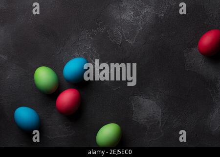 Easter eggs on black textured background, top view, space Stock Photo