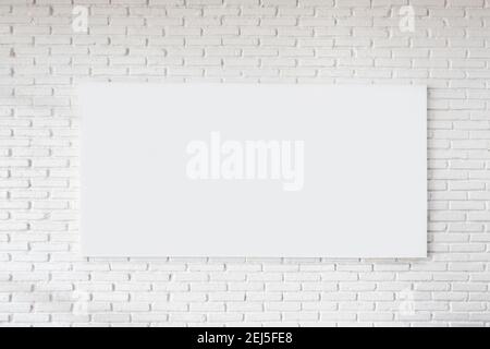 Decorator hanging frame on a white brick wall in the room. Interior design. Mockup poster. Stock Photo