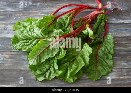 Fresh raw leaves of chard, leaf beets, mangold, swiss chard on a wooden table, close up Stock Photo