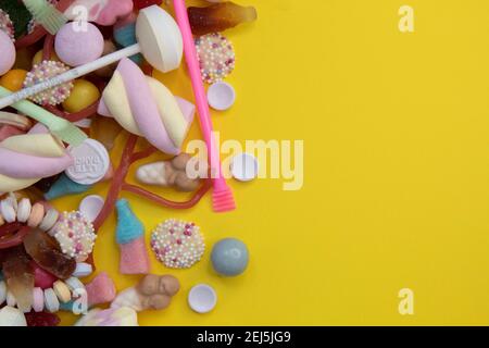 Overhead view of ice cream cone with lollipop, jellybeans and sprinkles spilling out. Stock Photo