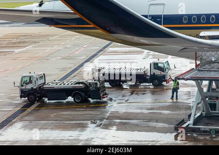 Lavatory service vehicles for emptying and refilling lavatories onboard aircraft of a Singapore Airlines machine at apron of Changi Intern. Airport Stock Photo