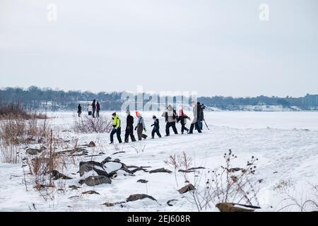 Cleveland, Ohio, USA. 21st Feb, 2021. People rescued off the ice of Lake Erie by members of the USCG Ice Rescue Team from Station Cleveland, as well as other local rescue agencies are seen safely escorted to shore late Sunday afternoon, February 21, 2021 at Edgewater Park in Cleveland, Ohio. At 12:43 EST, the National Weather Service in Cleveland issue a warning to not go onto the ice due to development of significant cracks from southerly winds. According to a Tweet from the USCG Great Lake, the '''¦ USCG ice rescue team rescued 6 individuals via the ice skiff and the other 4 were escort Stock Photo