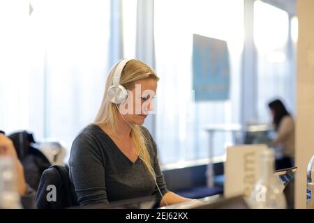 businesswoman in headphones working on  computer at modern bright office. Stock Photo