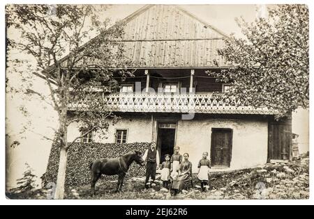 Vintage photo farmer family with horse in front of house. Country life style