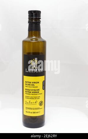 Glass bottle of premium virgin olive oil, lemon and some olives with ...