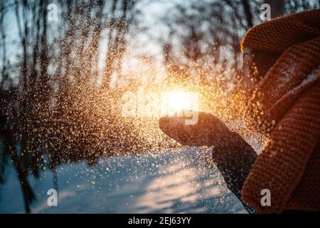 beautiful female in gloves blowing snow and have fun outdoor in winter park Stock Photo