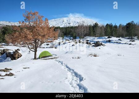 green tent in the snow of Etna National Park, Sicily Stock Photo