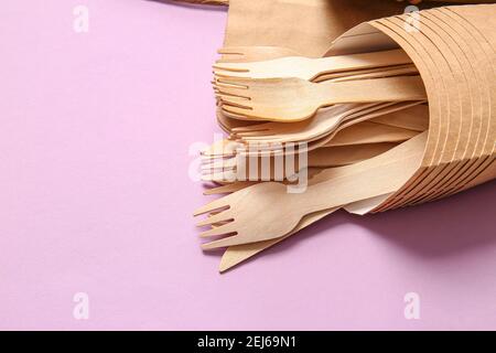 Wooden forks in containers on color background Stock Photo