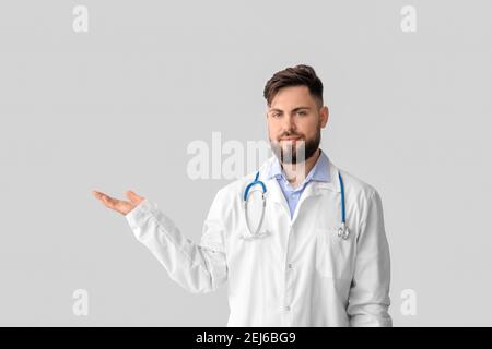 Doctor holding something on light background Stock Photo