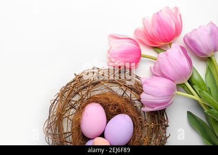 Beautiful Easter composition with eggs and spring flowers on white background Stock Photo