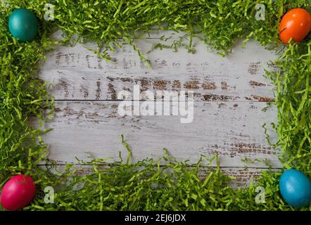 Easter grass with 4 colorful easter eggs in each corner frame, with copy space Stock Photo