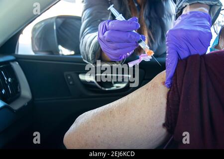 An 84 year old, Latina woman, gets her second Moderna vaccine injection  to help stop the spread of the COVID-19 virus; Dodger Stadium, L.A. CA USA. Stock Photo