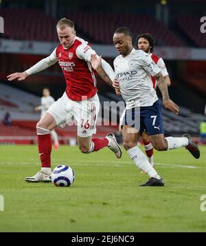 London, Britain. 21st Feb, 2021. Manchester City's Raheem Sterling (R) vies with Arsenal's Hector Bellerin during the English Premier League football match between Arsenal and Manchester City at the Emirates Stadium in London, Britain, on Feb. 21, 2021. Credit: Han Yan/Xinhua/Alamy Live News Stock Photo