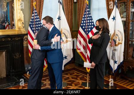 Vice President Kamala Harris looks on as Pete Buttigieg embraces his husband, Chasten Buttigieg, after being sworn in as Secretary of Transportation Wednesday, Feb. 3, 2021, in the Vice President’s Ceremonial Office in the Eisenhower Executive Office Building of the White House. (Official White House Photo by Lawrence Jackson) Stock Photo