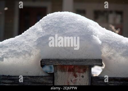 Freshly fallen snow piled on top of a wooden fence on a sunny day in Ottawa, Ontario, Canada. Stock Photo
