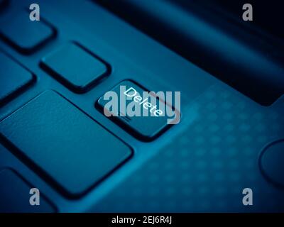 Delete key on black keyboard of laptop computer. Close up small embossed on delete button. Stock Photo