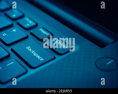 Delete key on black keyboard of laptop computer. Close up small embossed on delete button. Stock Photo