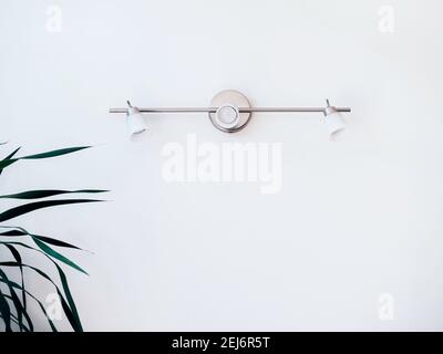 Wall light decoration on white background. Three light bulbs, wall lamp on metal mounted on clean wall, minimal style. Stock Photo