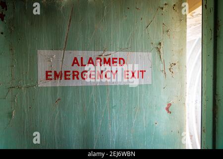 Interior of a painted emergency exit door. The door is in a poor state of repair and has an interesting color and texture. Stock Photo