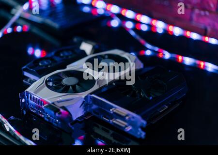 The video cards are on the table in a row one after the other. A component part of a computer for cryptocurrency mining and games. Stock Photo