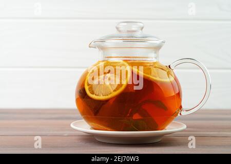 Glass teapot with black tea and pieces of citrus Stock Photo