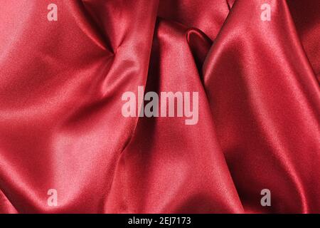 Shiny red satin textile texture with folds Stock Photo