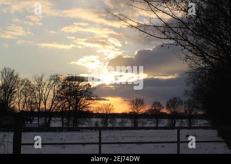 A beautyful sunset with cloudy sky and trees in the background Stock Photo