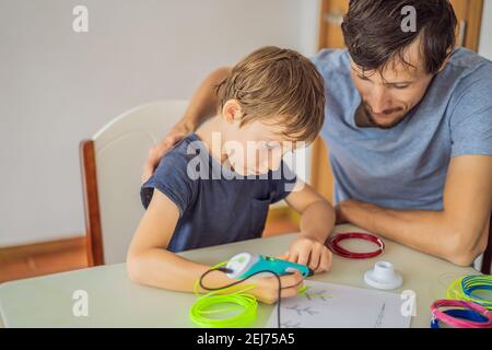 Boy and his father using 3d printing drawing pen. Creative, leisure, technology education concept Stock Photo