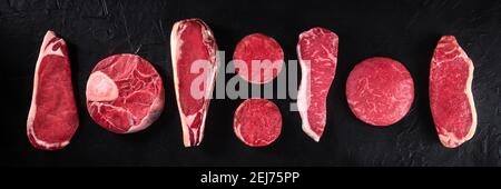 Meat panorama. Various cuts of raw beef, overhead flat lay shot on a black background Stock Photo