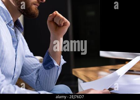 Cropped image of a focused businessman reading a plan or carefully analyzing a document. Stock Photo
