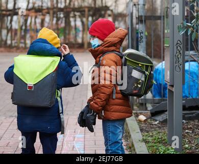 Berlin, Germany. 22nd Feb, 2021. Two students wearing medical masks come with school bags to the entrance of an elementary school in Prenzlauer Berg. For schools in Berlin, the gradual opening began on Monday morning after a good two months of corona-induced homeschooling. Initially, in addition to the graduating classes, only the children of the 1st to 3rd grade will be partially taught at school again. (to dpa 'Berlin's schools reopen - the youngest come back first' Credit: Annette Riedl/dpa/Alamy Live News Stock Photo