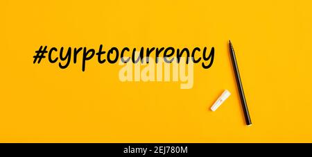 The word cryptocurrency hand written with hashtag symbol and a pen marker on yellow background. Stock Photo