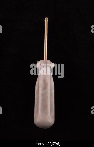 gray screwdriver on a black background Stock Photo