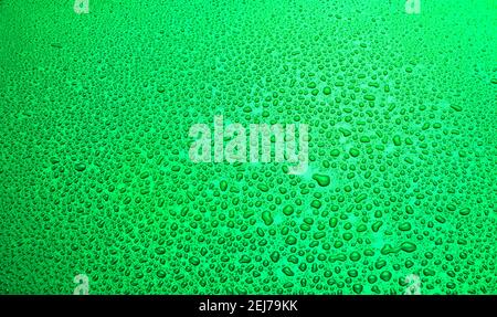 water drop background. rain drops on green metal surface Stock Photo
