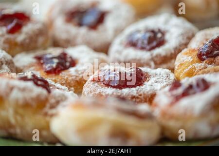 Detail of a plate of donuts filled with jam and coated in sugar. Stock Photo