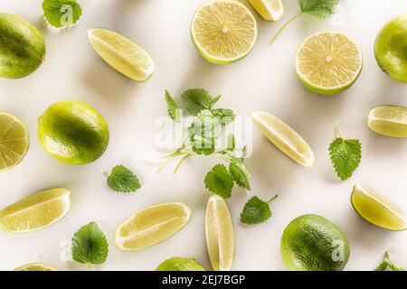 Freshly cut lime and mint leaves on a white background. Stock Photo