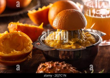 Freshly squeezed orange in a manual juicer with pulp, juice and orange skins leftovers. Stock Photo