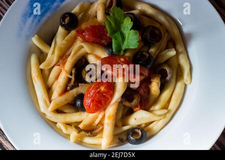 Fusilli al ferro with black olives and cherry tomatoes Stock Photo
