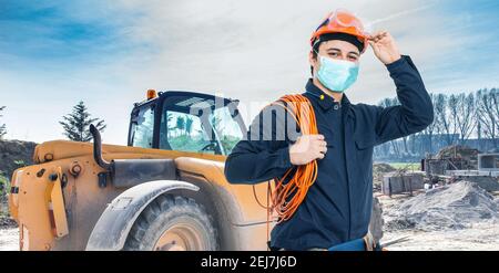 Portrait of masked worker in a construction site, covid coronavirus construction concept Stock Photo