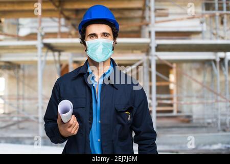 Masked architect portrait in a site plant, covid coronavirus construction site concept Stock Photo